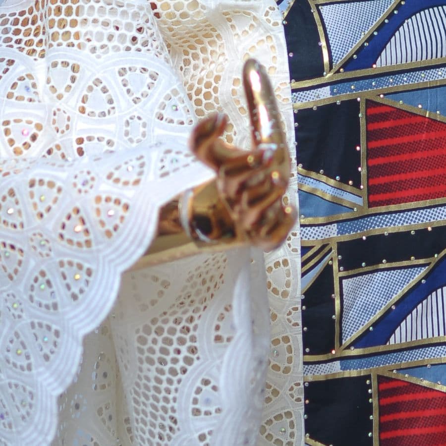 Close-up of cream eyelet lace over an Ankara print.